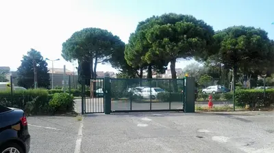 a gate in a parking lot with a fire hydrant at Appartement vue mer in Gruissan