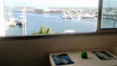 a window with a view of a marina with boats at Appartement vue mer in Gruissan
