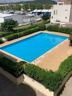 an overhead view of a large blue swimming pool at Appartement vue mer in Gruissan