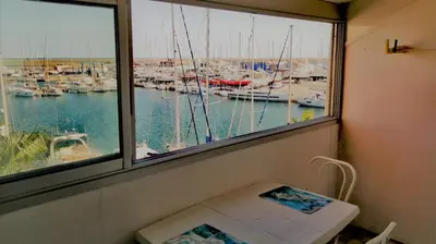 a window with a view of a marina with boats at Appartement vue mer in Gruissan