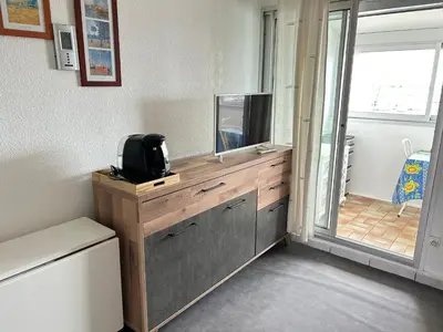 a room with a wooden dresser with a tv on it at Appartement vue mer in Gruissan