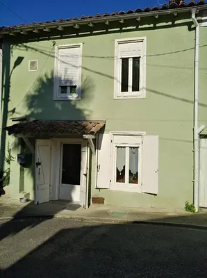 a green house with white doors and windows at Repos au vert en Ariège in Le Peyrat