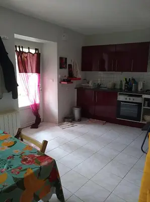 a kitchen with a table and a kitchen with a window at Repos au vert en Ariège in Le Peyrat