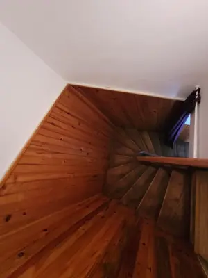 an attic staircase with wood floors and a white wall at Repos au vert en Ariège in Le Peyrat