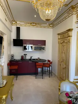 a kitchen with a table and chairs and a chandelier at Suite Impériale Église du Couvent in Narbonne
