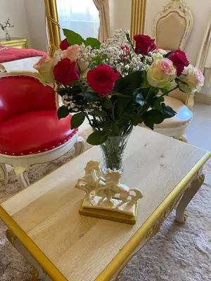 a vase of flowers on a table in a room at Suite Impériale Église du Couvent in Narbonne