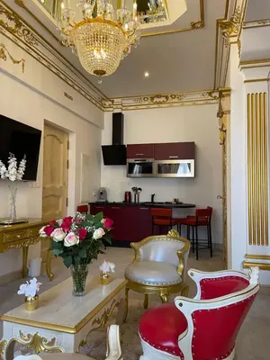 a living room with red and white chairs and a table at Suite Impériale Église du Couvent in Narbonne