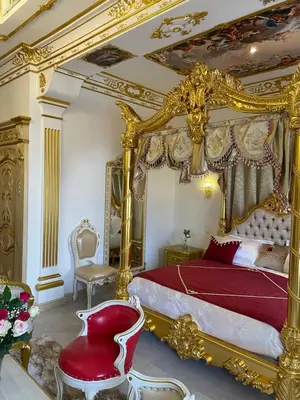a bedroom with a gold canopy bed and a chair at Suite Impériale Église du Couvent in Narbonne