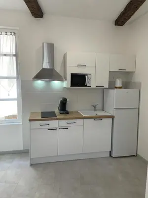 a kitchen with white cabinets and a microwave at Maison du Cloitre Couvent des Carmes in Narbonne