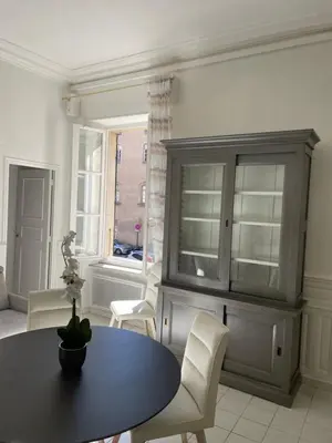 a living room with a table and chairs and a cabinet at Maison du Cloitre Couvent des Carmes in Narbonne