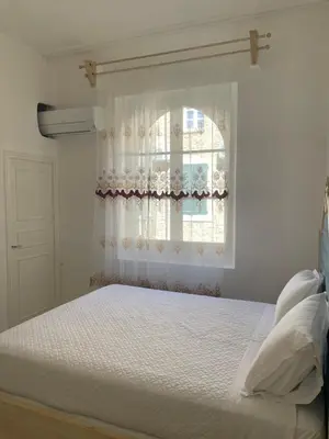 a bedroom with a white bed with a window at Maison du Cloitre Couvent des Carmes in Narbonne