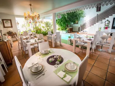 a dining room with white tables and white chairs at Chambre d'Hôtes Villa Ambrosia et Spa in Narbonne