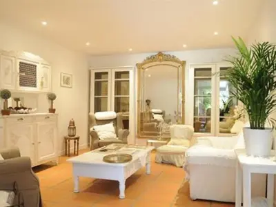 a living room with white furniture and a mirror at Chambre d'Hôtes Villa Ambrosia et Spa in Narbonne