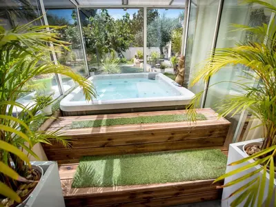 a hot tub in the middle of a room with plants at Chambre d'Hôtes Villa Ambrosia et Spa in Narbonne