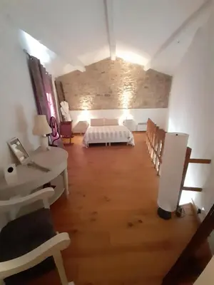 a room with a bed and a table and chairs at La maisonnette avec SPA, PISCINE et CLIMATISATION in Sainte-Vallière