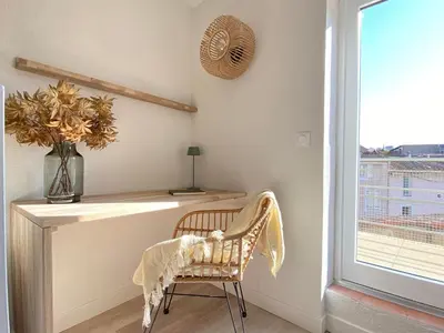 a chair in a room with a desk and a window at La Terrasse sur les Toits in Narbonne