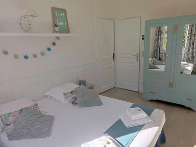 a bedroom with two beds and a clock on the wall at La Villa Carcassonne, Chambres d hôtes, B&B, face à la Cité Médiévale in Carcassonne
