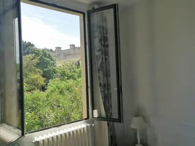 an open window with a view of a castle at La Villa Carcassonne, Chambres d hôtes, B&B, face à la Cité Médiévale in Carcassonne