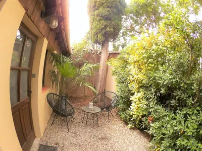 a patio with two chairs and a table next to a building at La Villa Carcassonne, Chambres d hôtes, B&B, face à la Cité Médiévale in Carcassonne