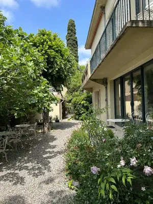 a house with chairs and tables in the yard at La Villa Carcassonne, Chambres d hôtes, B&B, face à la Cité Médiévale in Carcassonne