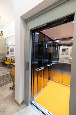 a glass door in a building with a yellow floor at Chambre Familiale Maison de L'Église du Couvent in Narbonne