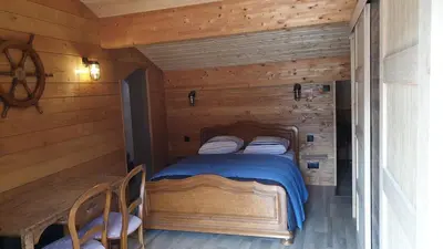 a bedroom with a bed in a log cabin at MAURY CAT'STUDIO 66 in Maury