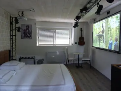 a bedroom with a bed and a table and a window at MAURY CAT'STUDIO 66 in Maury
