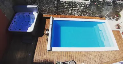 a swimming pool sitting on top of a wooden deck at Le Clos'art in Vinassan