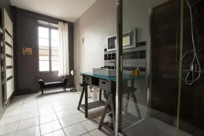 a bathroom with a shower and a desk in a room at Le Clos'art in Vinassan