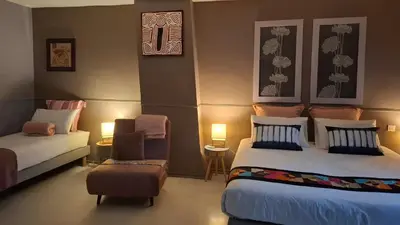 a bedroom with two beds and a couch and a chair at Le Clos'art in Vinassan