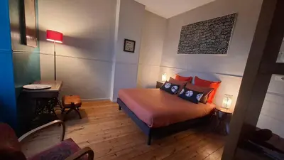 a bedroom with a bed and a table with a lamp at Le Clos'art in Vinassan