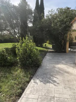 a walkway in a garden with trees and a bench at Gîte la Lezardière accès privé canal du midi ** in Castelnaudary