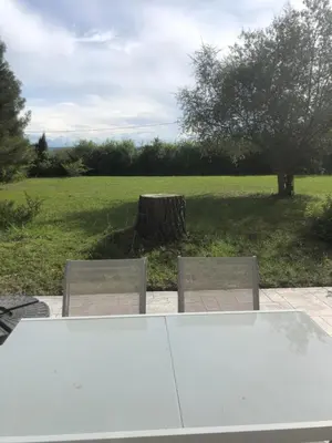 a white table and two chairs and a tree at Gîte la Lezardière accès privé canal du midi ** in Castelnaudary