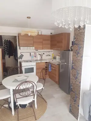 a kitchen with a table and chairs and a refrigerator at studio gruissan proche plage des chalets in Gruissan