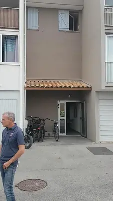 a man standing in front of a building with bikes at studio gruissan proche plage des chalets in Gruissan