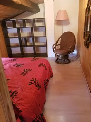 a bedroom with a red bed and a chair at LA BOULZANE in Puilaurens