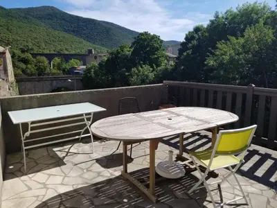 a table and two chairs on a patio with a view at LA BOULZANE in Puilaurens
