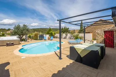 a patio with a swimming pool with a table and a table at Villa avec piscine et Jaccuzy in Bize-Minervois