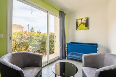 a living room with two chairs and a large window at Villa avec piscine et Jaccuzy in Bize-Minervois