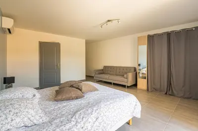 a bedroom with a bed and a couch at Villa avec piscine et Jaccuzy in Bize-Minervois