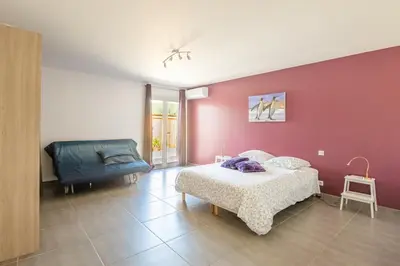 a bedroom with a bed and a chair at Villa avec piscine et Jaccuzy in Bize-Minervois