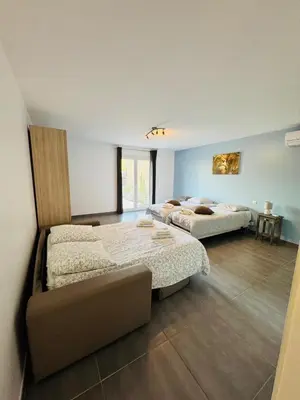 a bedroom with two beds and a couch in it at Villa avec piscine et Jaccuzy in Bize-Minervois