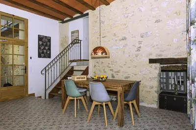 a dining room with a wooden table and chairs at Cottage - La Maison du Château - By DOMAINE RIBERACH in Bélesta