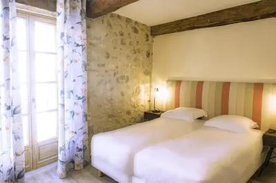 a bedroom with a white bed and a window at Cottage - La Maison du Château - By DOMAINE RIBERACH in Bélesta