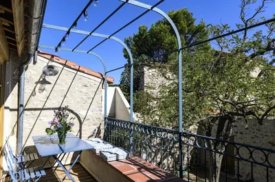 a balcony with a table with a vase on it at Cottage - La Maison du Château - By DOMAINE RIBERACH in Bélesta