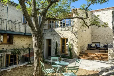 a patio in front of a house with a tree at Cottage - La Maison du Château - By DOMAINE RIBERACH in Bélesta