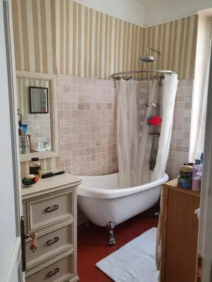a bathroom with a tub with a shower curtain at Maison Carrasserie in Limoux