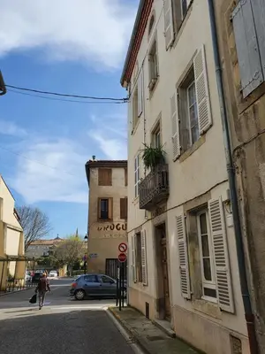 a person walking down a street next to a building at Maison Carrasserie in Limoux