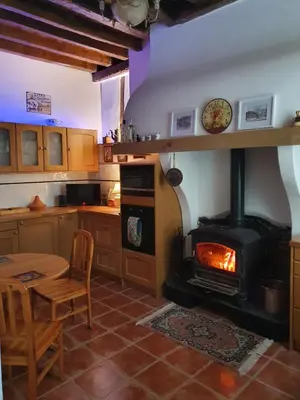 a kitchen with a stove and a table and a kitchen with a table at Maison Carrasserie in Limoux