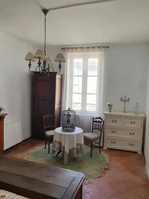 a living room with a table and chairs and a dresser at Maison Carrasserie in Limoux